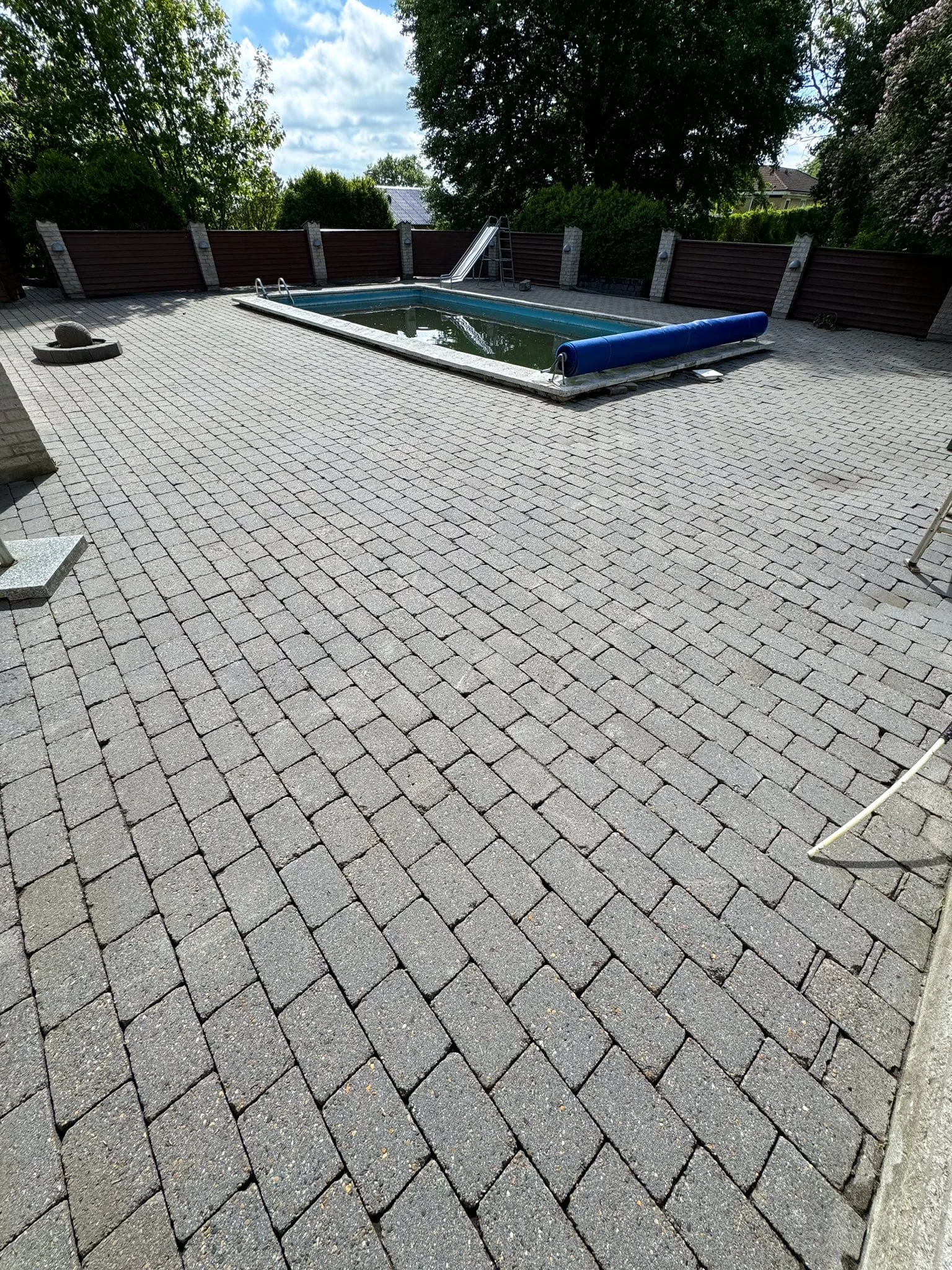 Udendørs swimmingpool med flisebelagt terrasse og rutsjebane