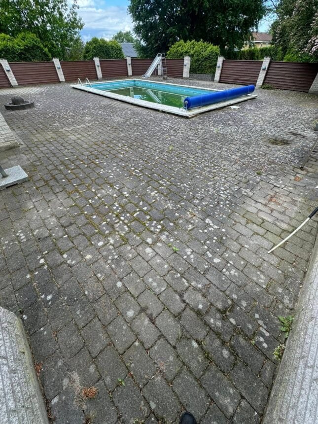 Udendørs swimmingpool med fliser og hegn i baghave